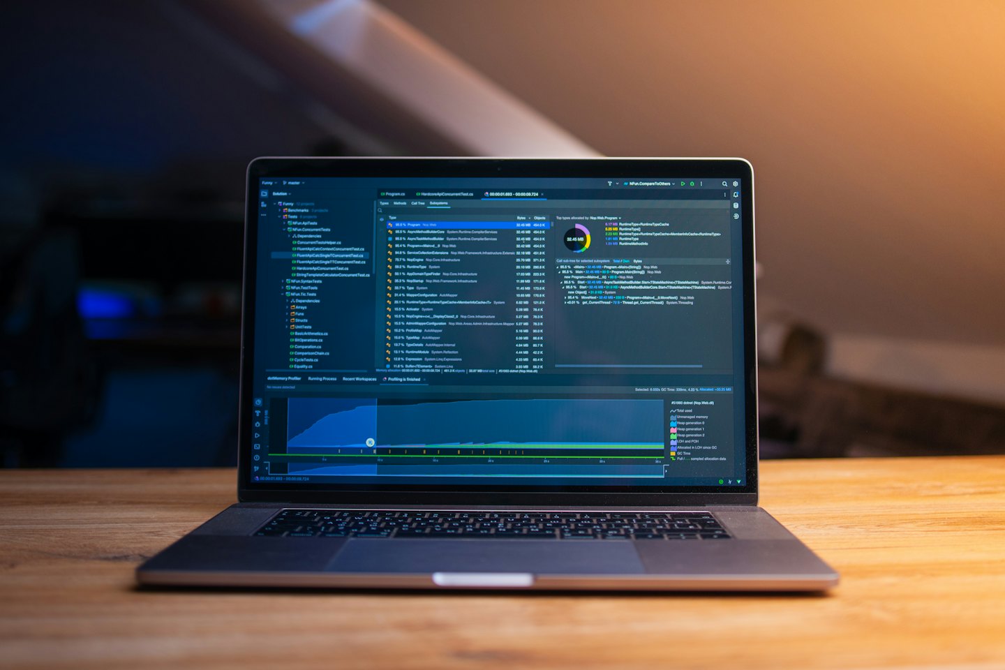 Computer portatile aperto con codice software e dati su una scrivania.
