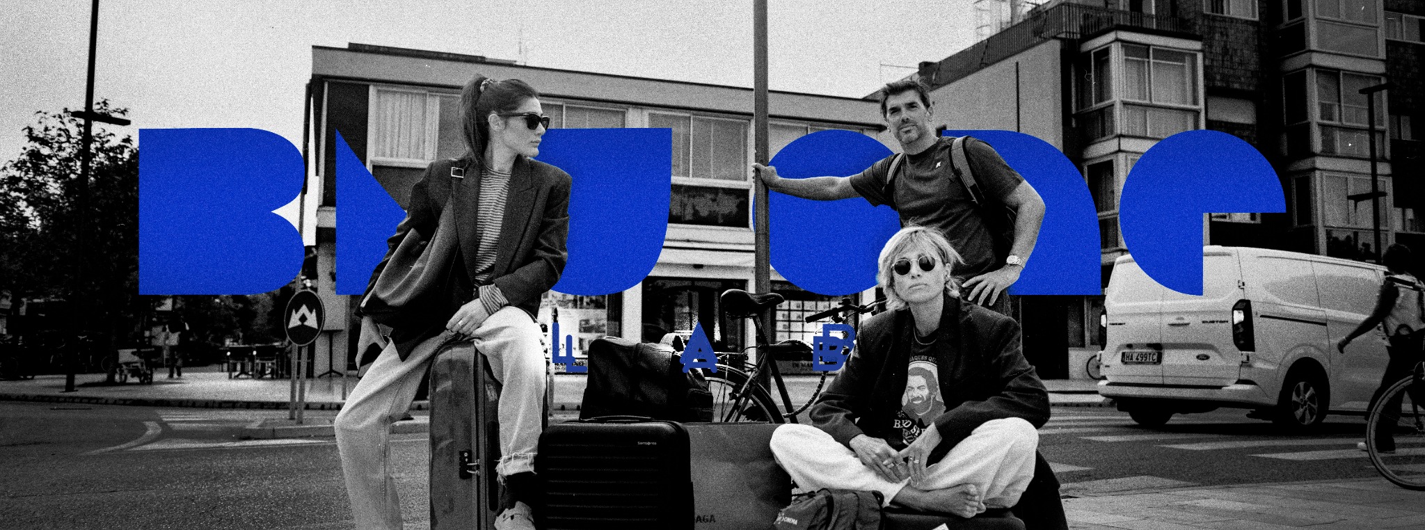 Fotografia in bianco e nero di tre persone in città, con il logo blu di Blu One Lab